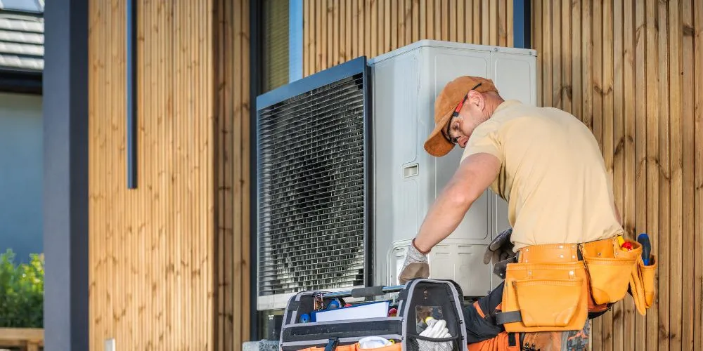 HVAC technician repairing an air conditioning unit outdoors. AC repair services in the DMV area for home cooling system maintenance.