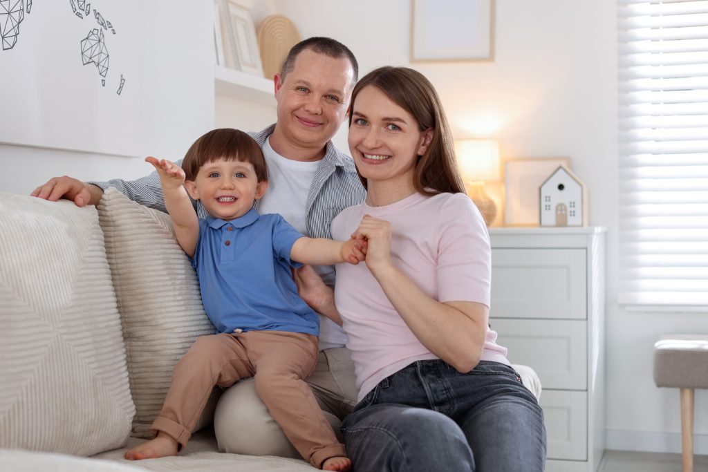 Happy family portrait indoors. While AC repair isn't depicted, ensuring home comfort for families like this is our priority. Call for AC service.